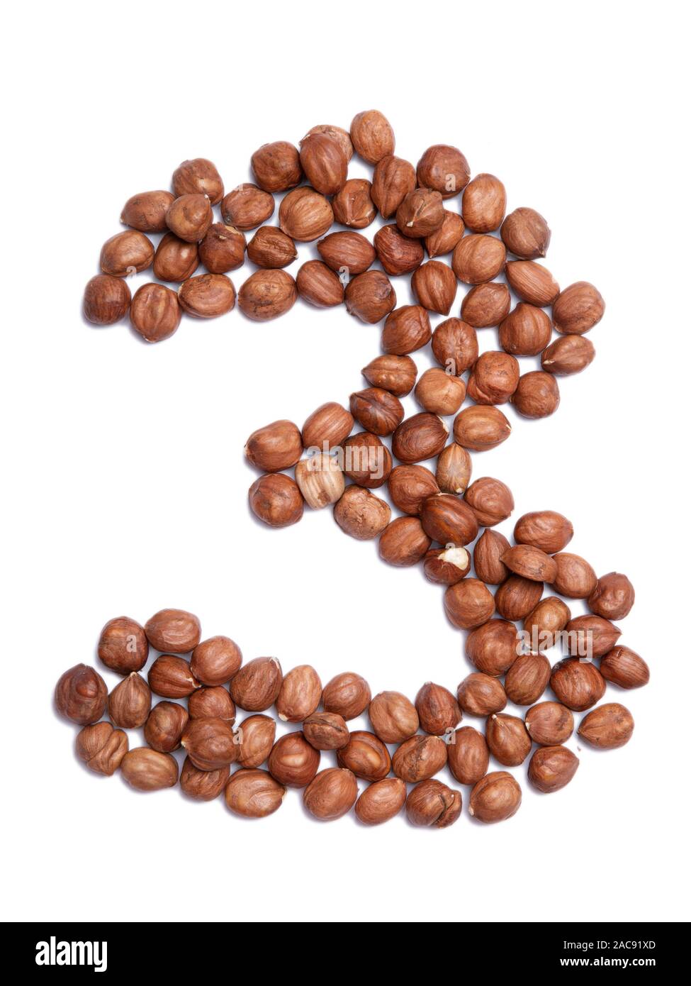 Arabic numeral "3" from peeled hazelnut on a white isolated background
