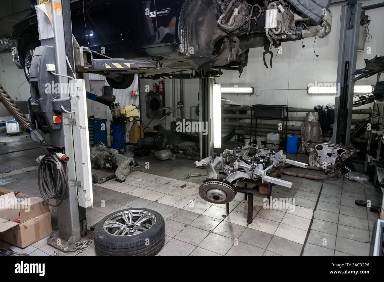 An Old Used Car Without Wheel Raised On A Lift For Repair And