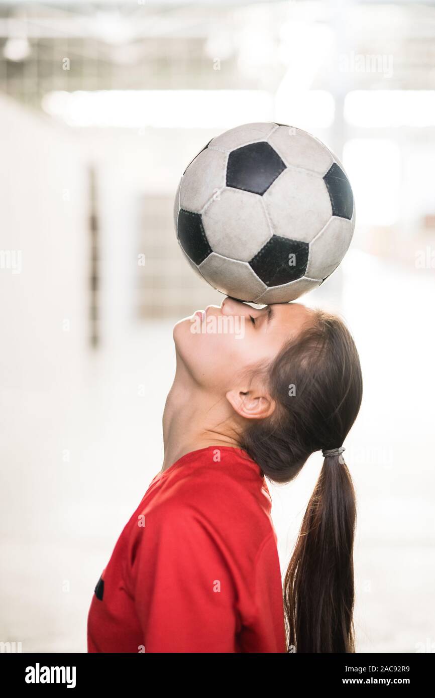 Young female football player in red t-shirt holding soccer ball on her ...
