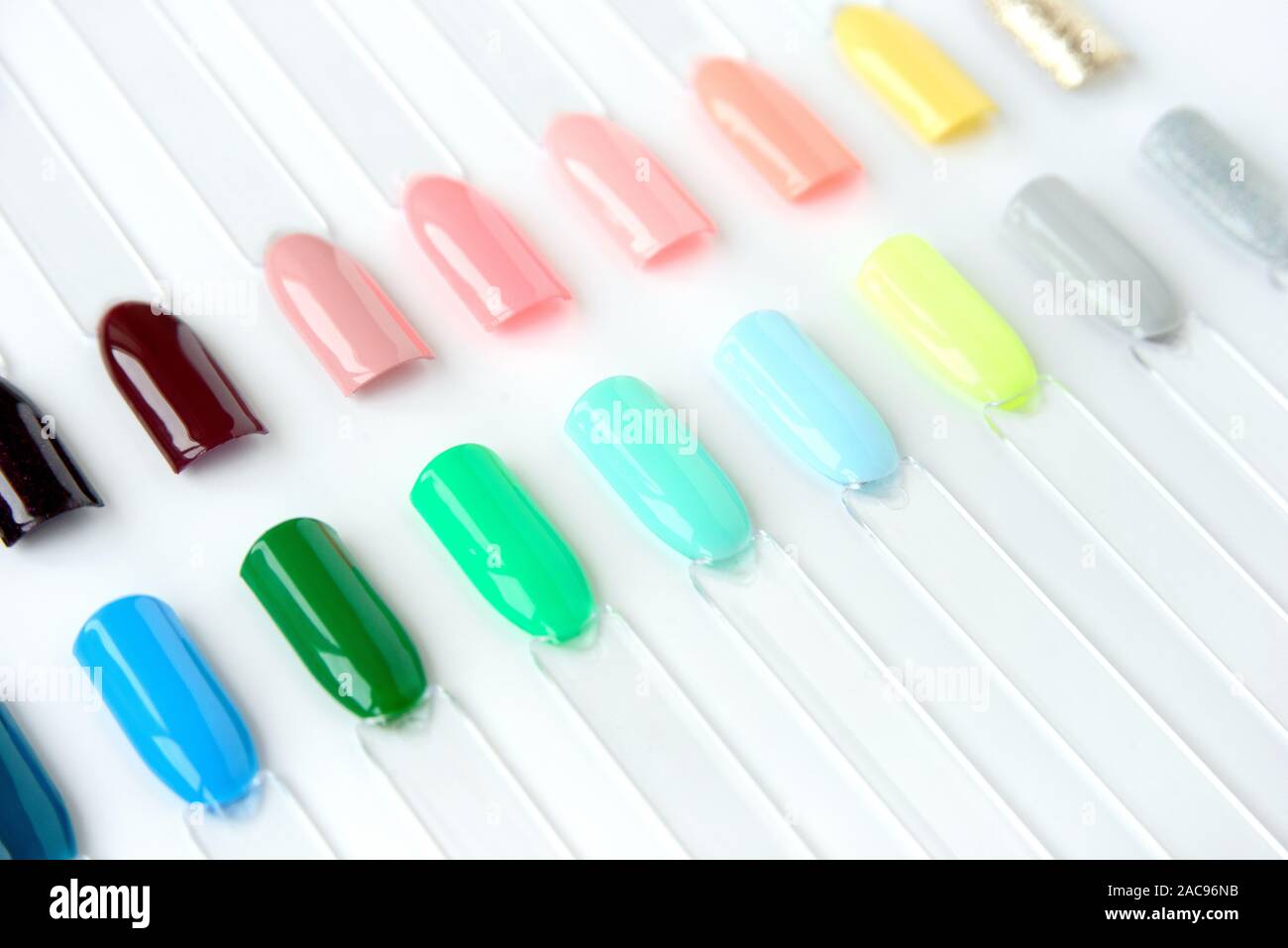 Nail polish samples in different bright colors. Colorful nail lacquer manicure swatches. Top view of nail art samples palette. Stock Photo