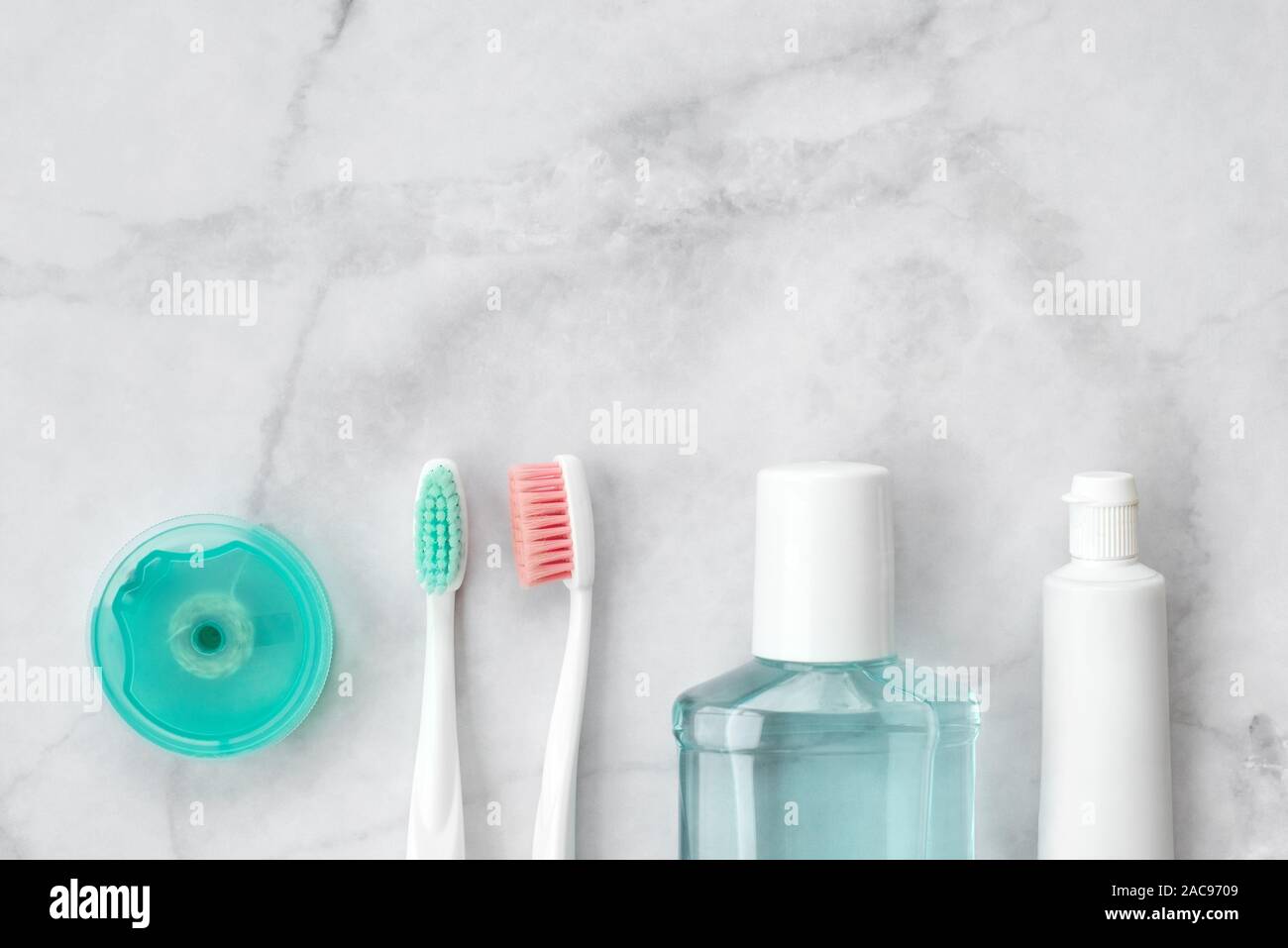 Set of pink and turquoise blue toothbrushes, toothpaste and other tools on marble background. Dental and health care concept. Top view, flat lay. Free Stock Photo