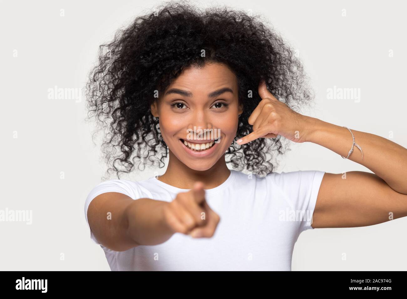 Attractive smiling African American woman showing call me gesture Stock Photo