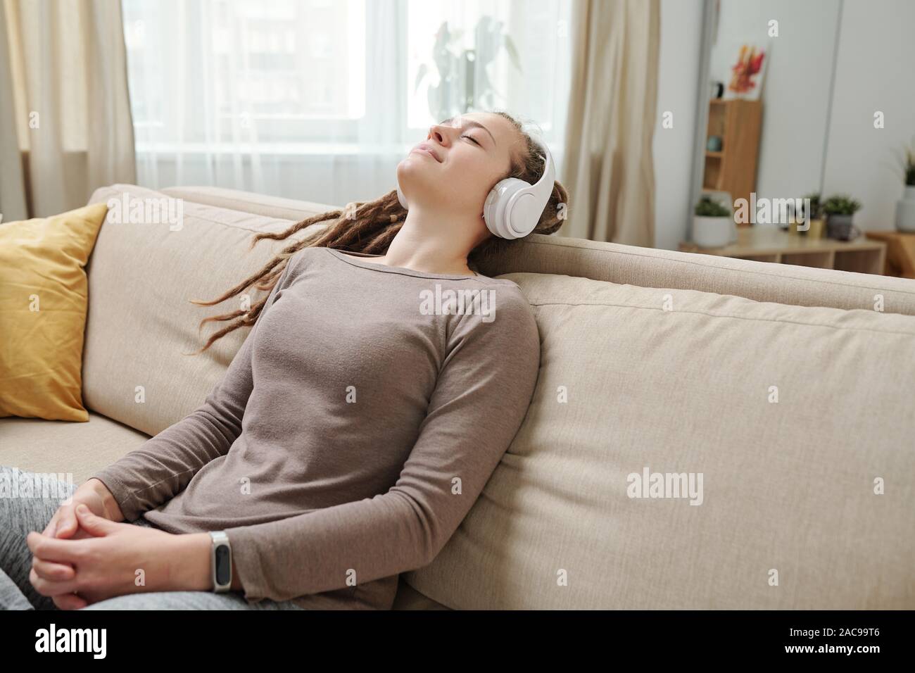 Happy young relaxed woman with headphones listening to meditation music Stock Photo