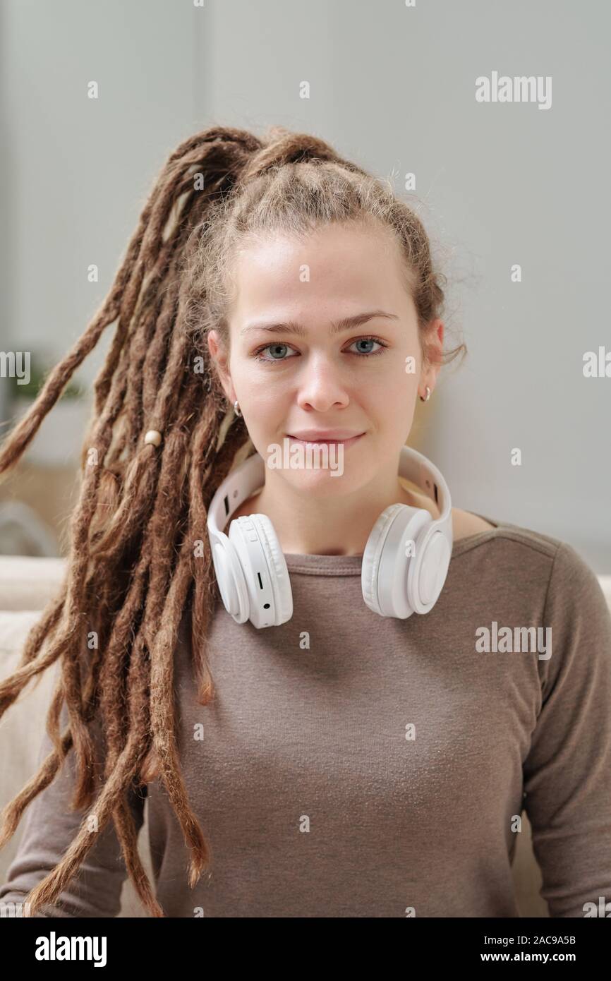 Pretty smiling girl in pullover with headphones around her neck Stock