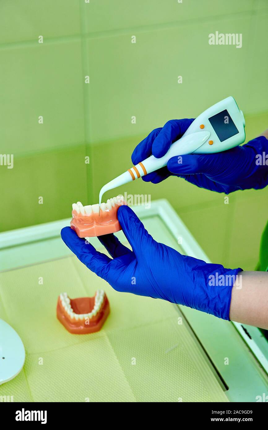 Dentist holding teeth model denture, showing with diagnostic