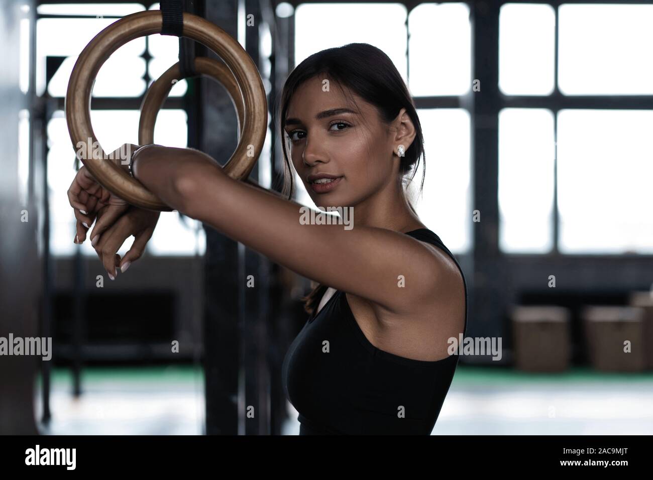 Exercising woman holding gymnast rings. Female taking rest after intense  dip ring workout at gym Stock Photo - Alamy