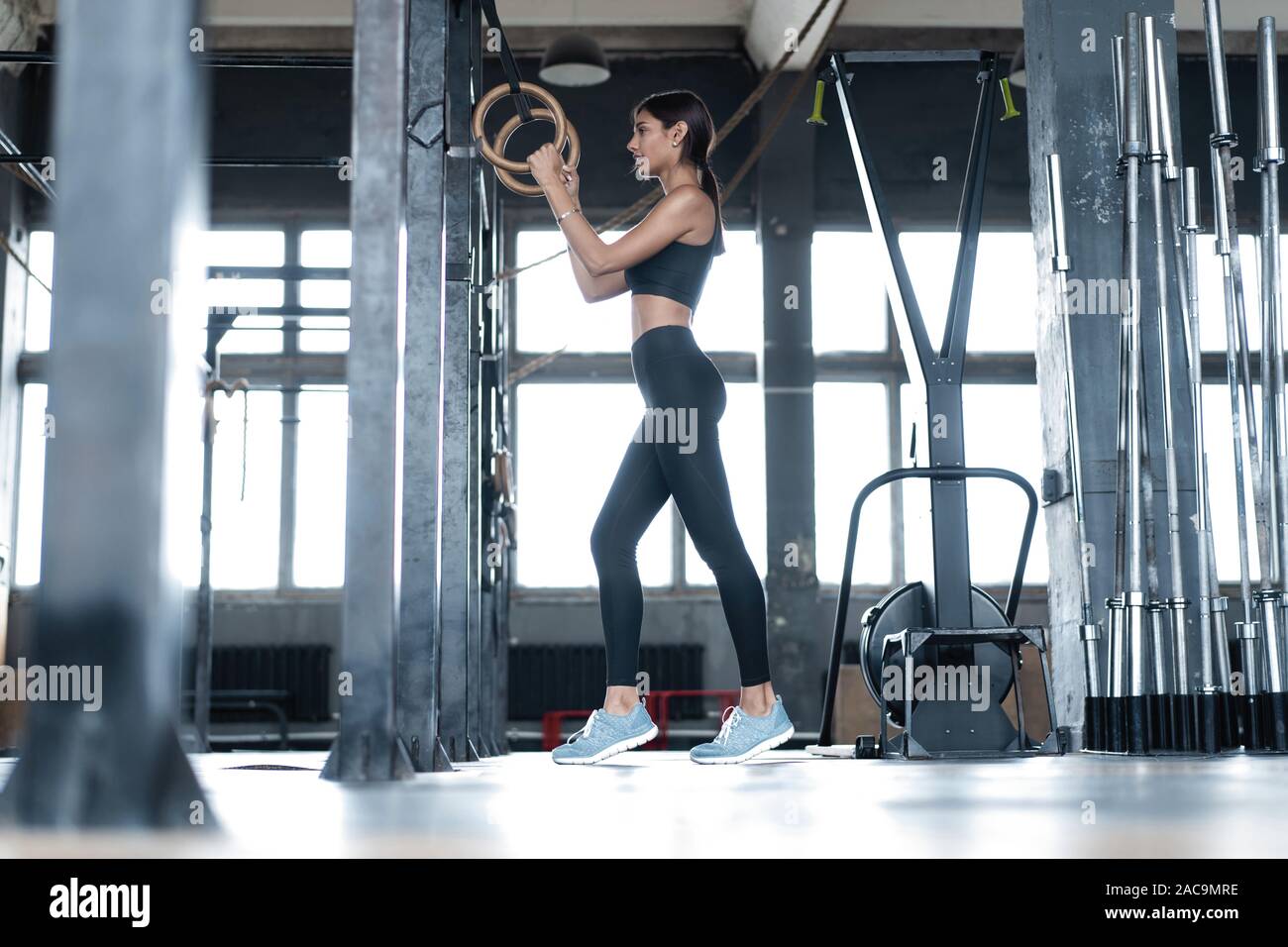 Exercising woman holding gymnast rings. Female taking rest after intense  dip ring workout at gym Stock Photo - Alamy