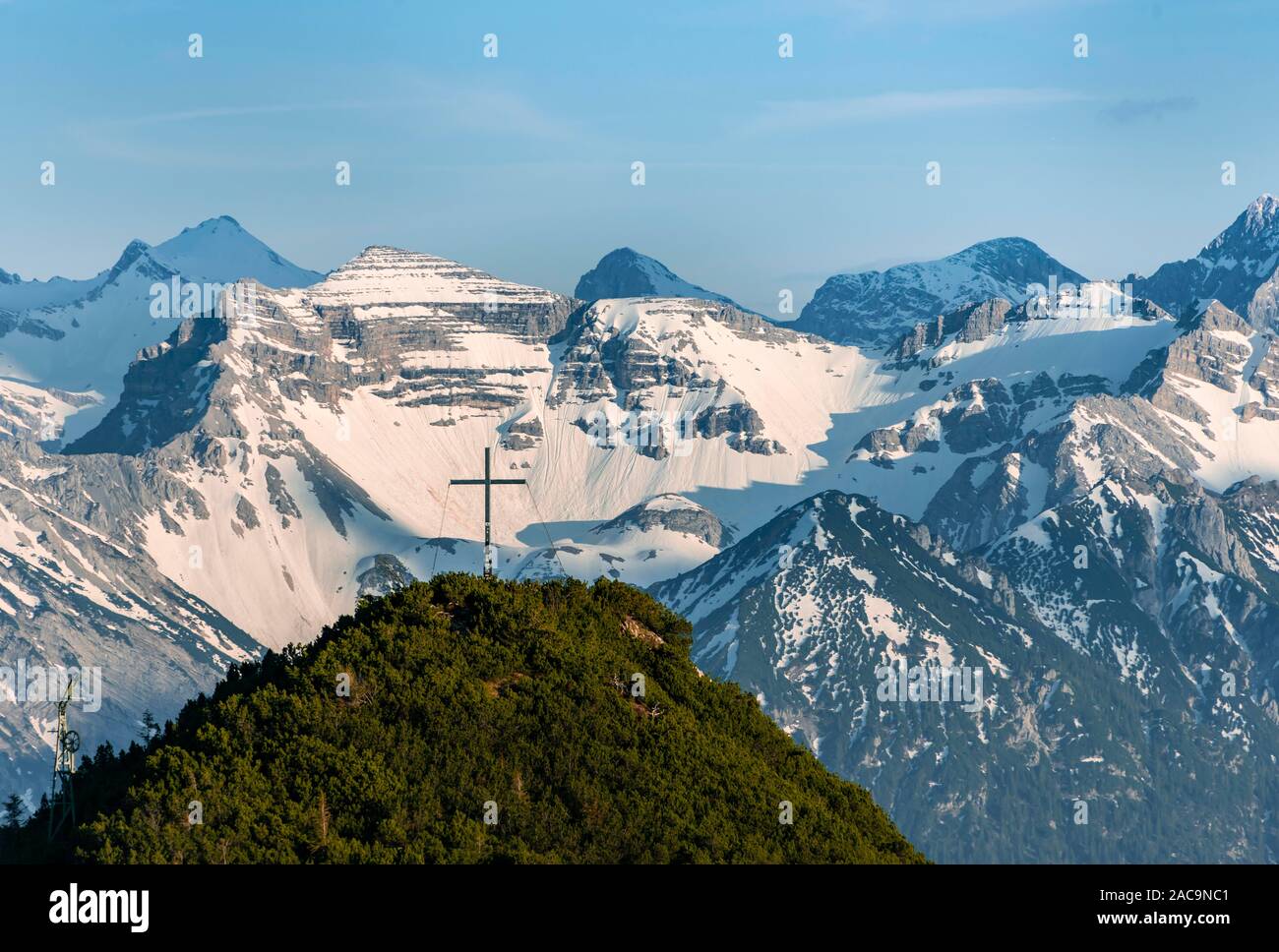 Summit cross am Martinskopf, view from Herzogstand, Karwendel Mountains at the back, snow covered mountains, Bavaria, Germany Stock Photo