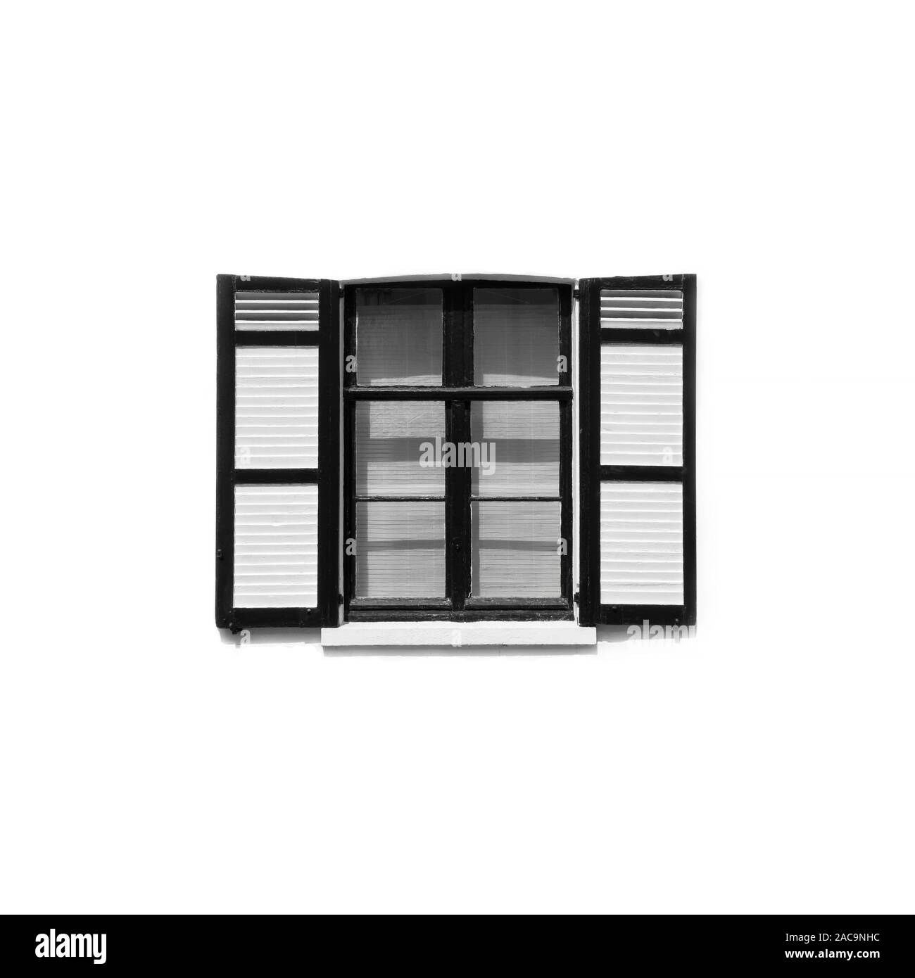 Black and white image of a window with open sheets in a white wall, minimal view Stock Photo