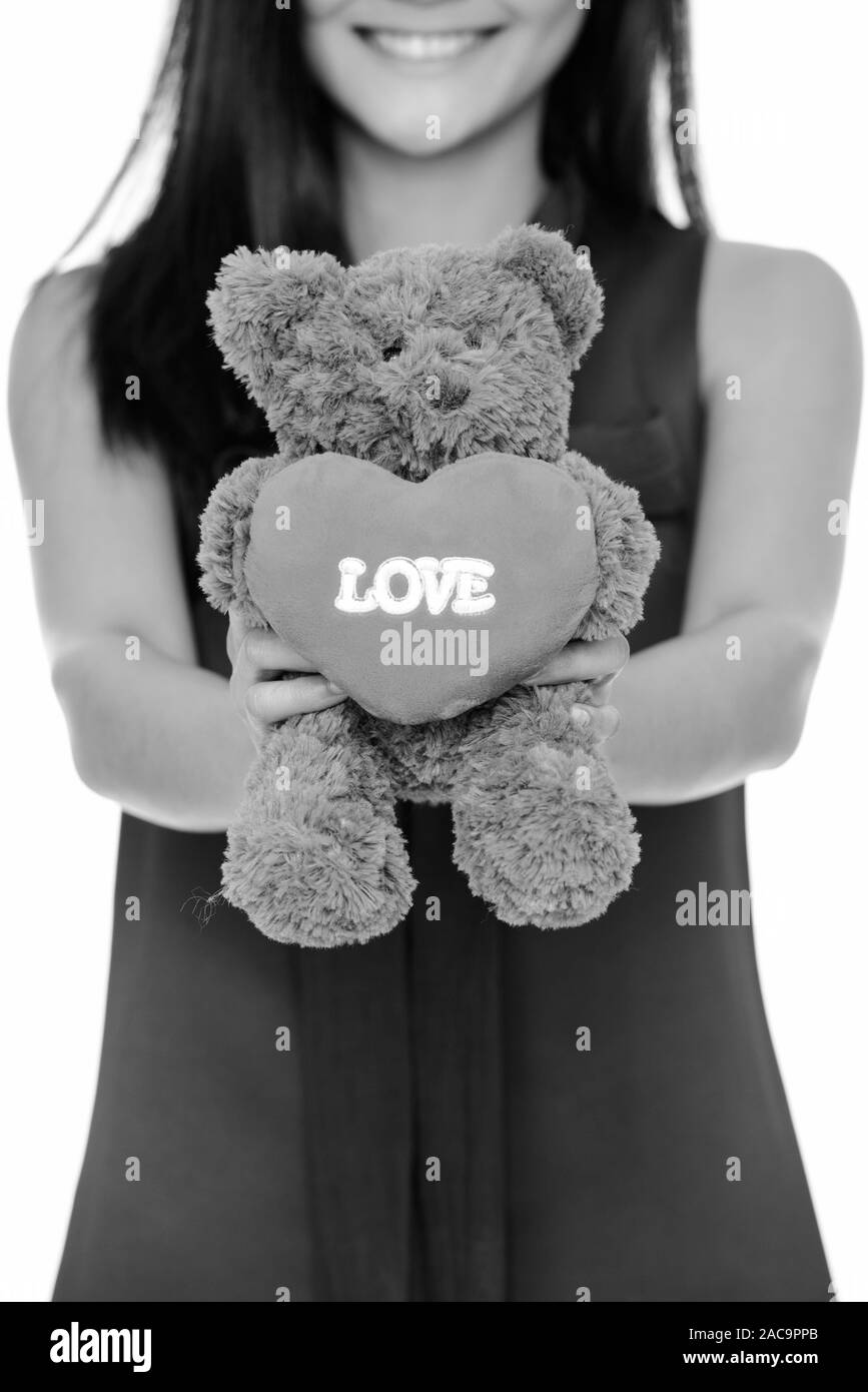 Young beautiful woman holding teddy bear with heart and love sign Stock Photo