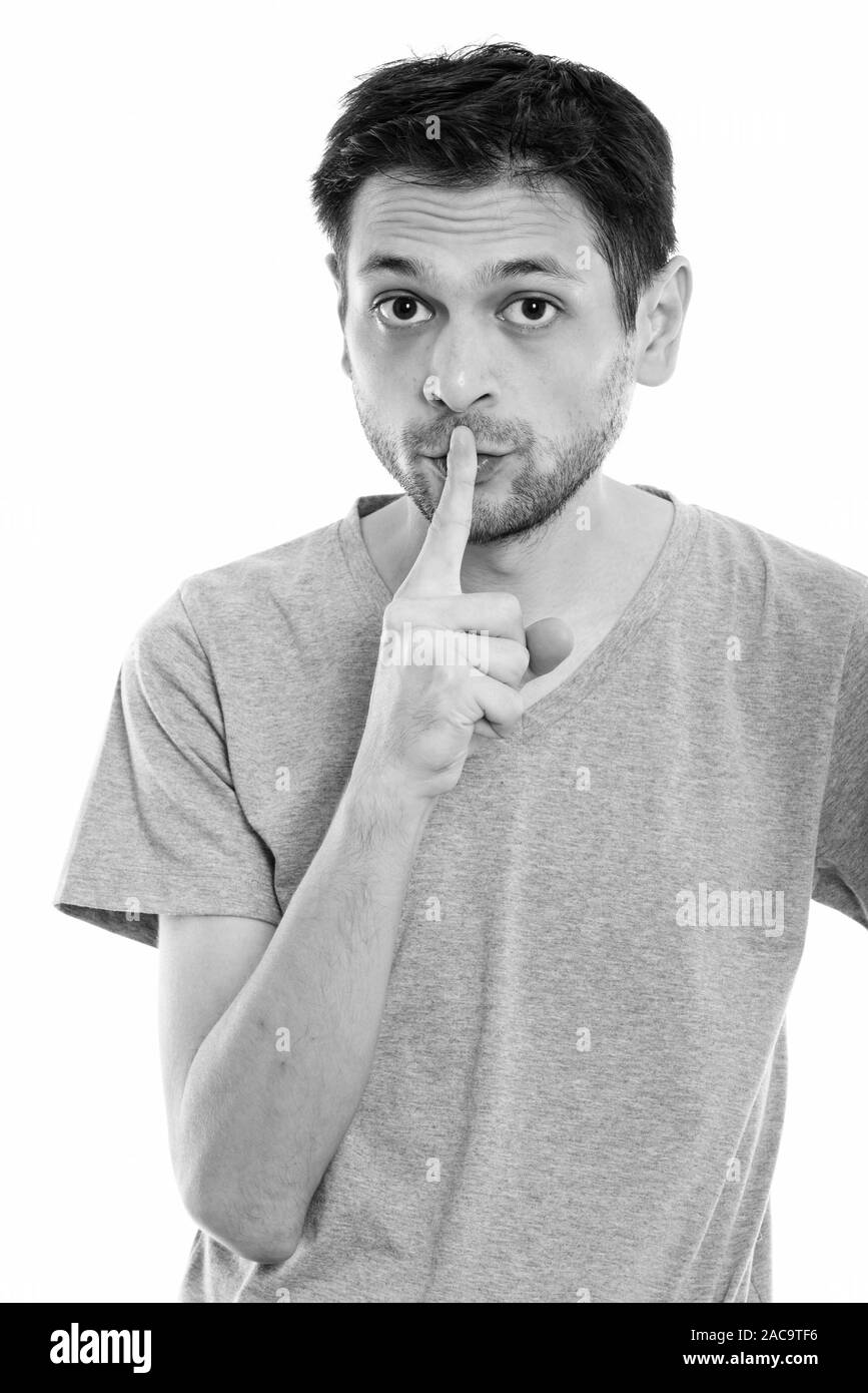 Studio shot of young man with finger on lips Stock Photo