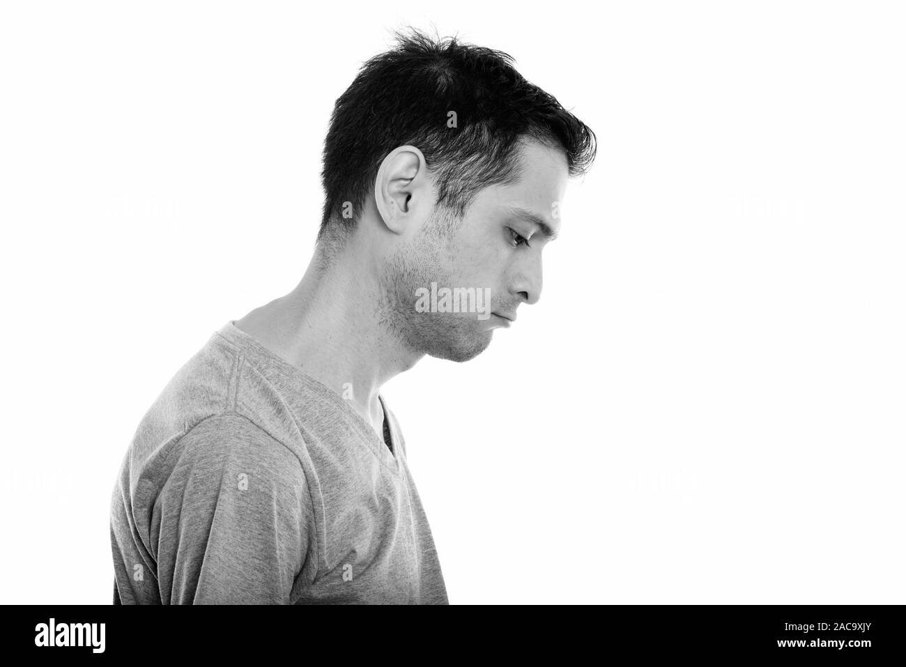 Profile view of sad young man looking down Stock Photo - Alamy