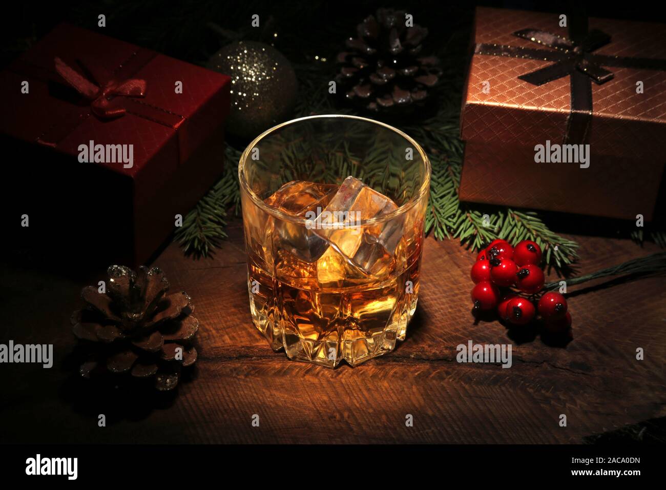 Glass with cognac or whiskey, Christmas balls and candles. New Year's tree, balls and glass with alcohol. Happy holidays decoration Stock Photo