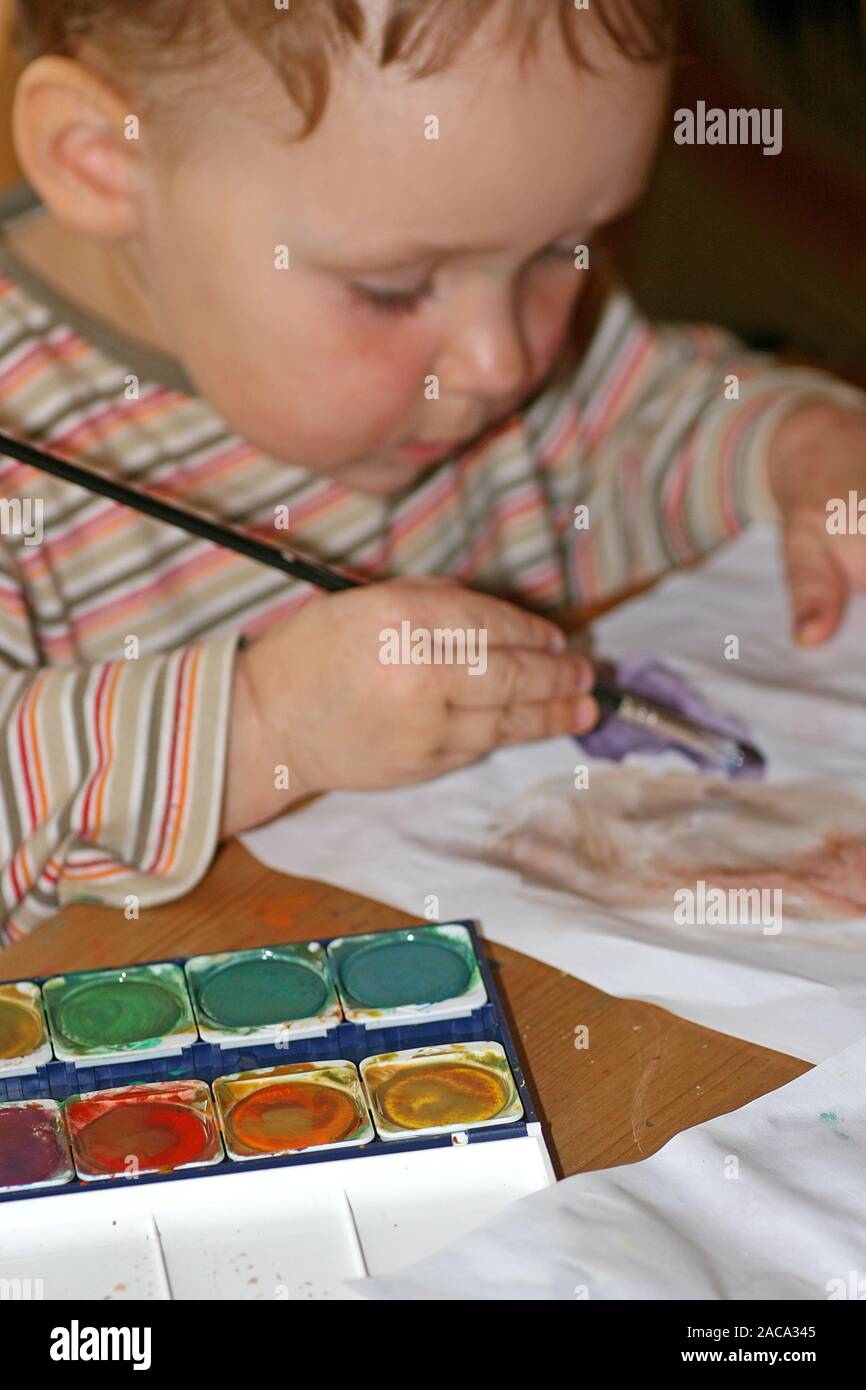 Child with watercolours and brush Stock Photo