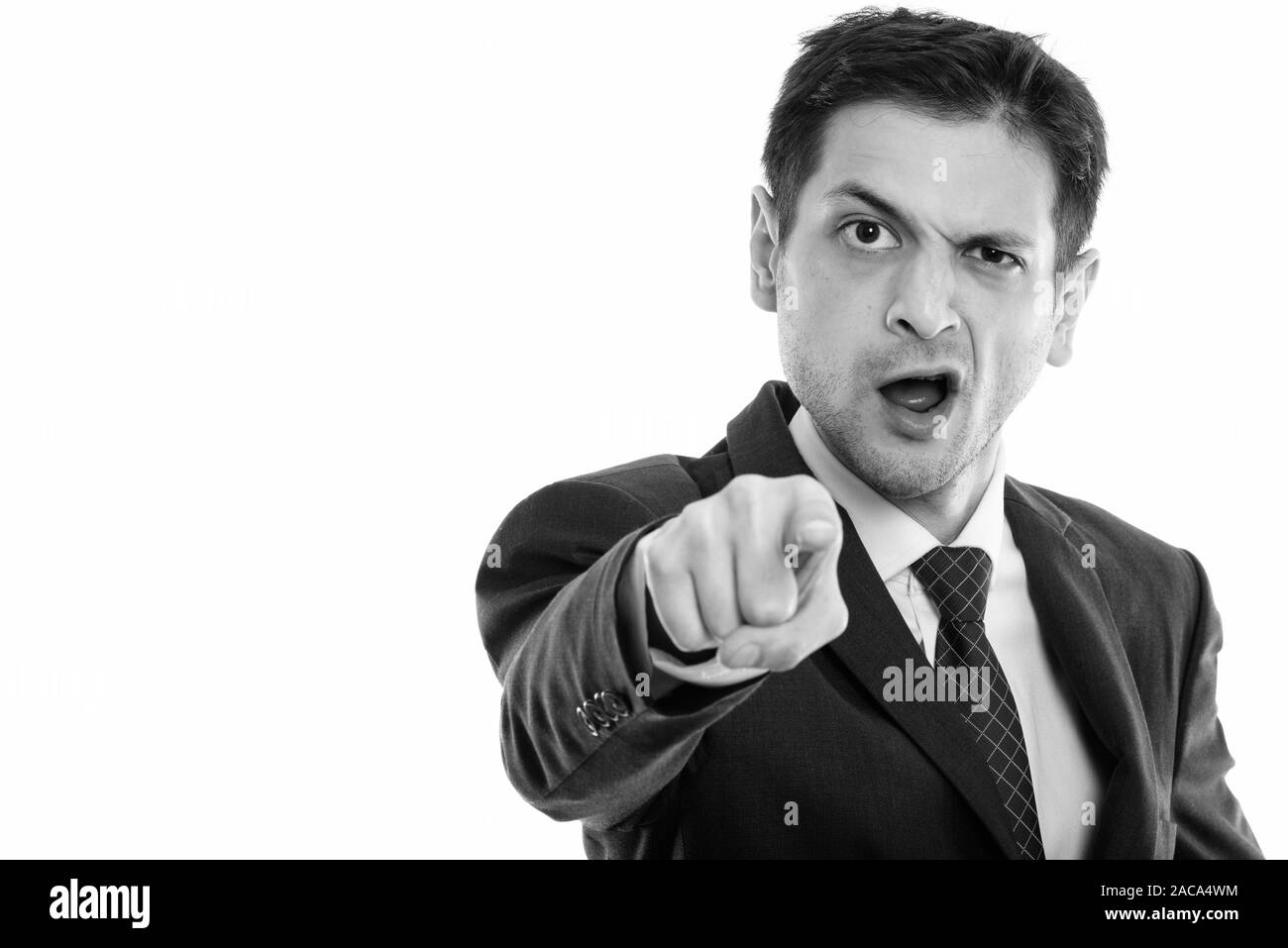 Studio shot of angry young businessman pointing at camera Stock Photo