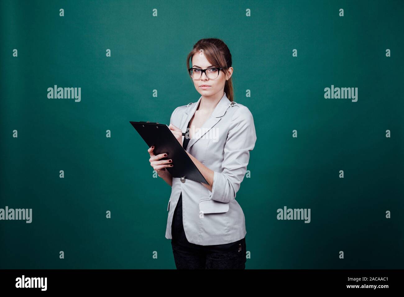 teacher in a business suit stands at green board Stock Photo - Alamy
