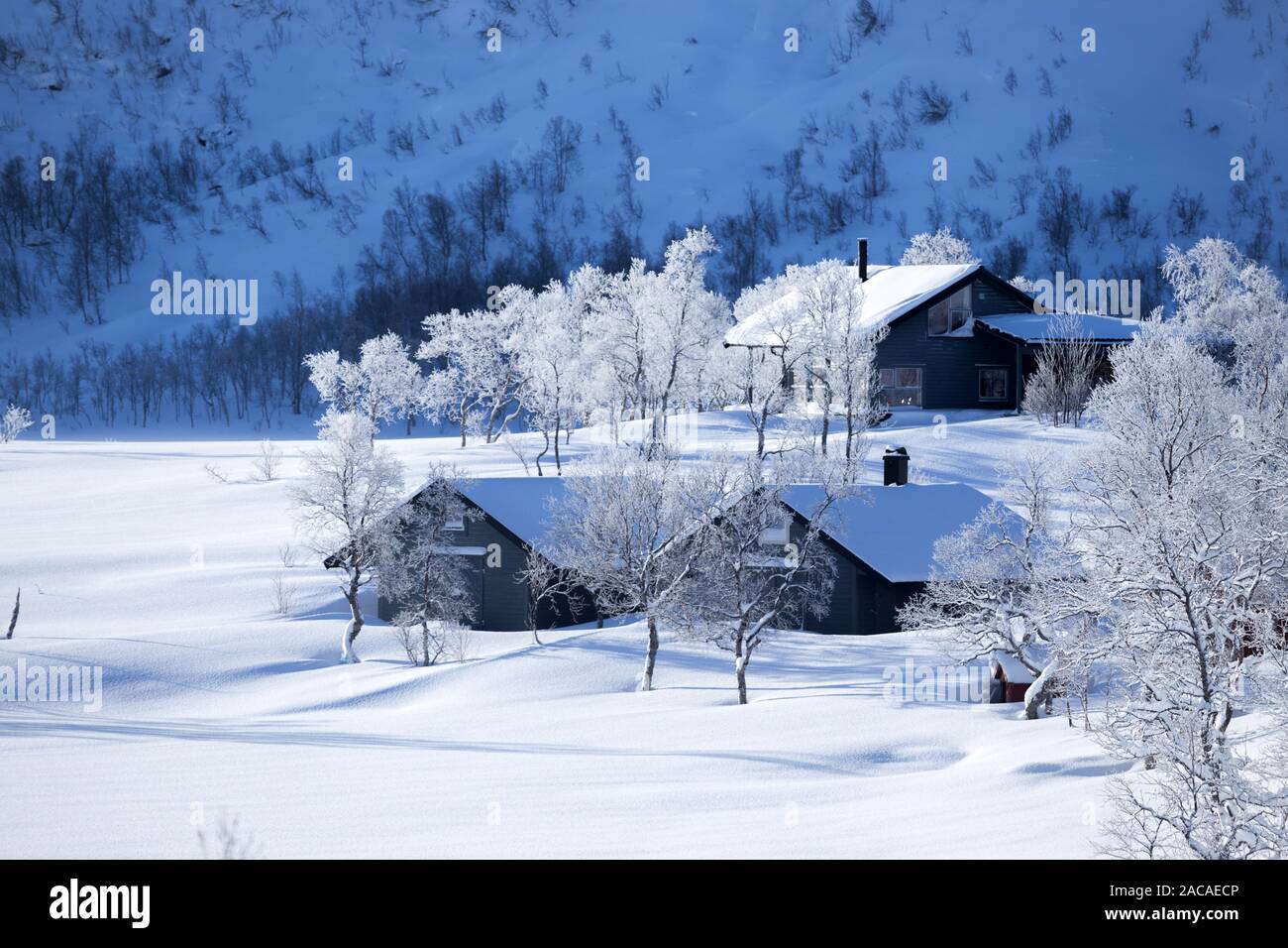 traditional norwegian wooden house and mountains in the distance