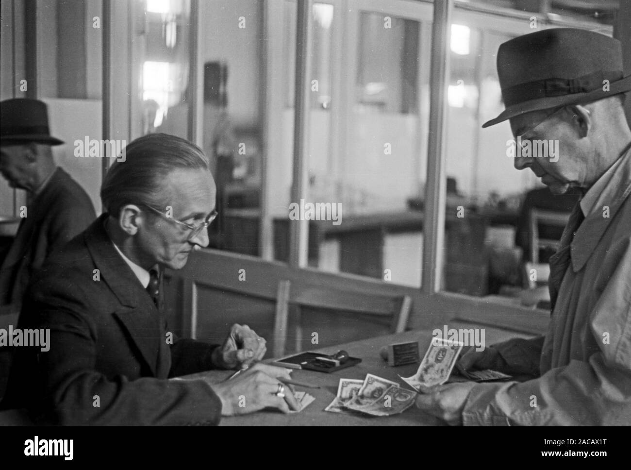 Männer in Wechselstube auf Leipziger Messe, Sachsen, Deutschland, 1948. Men in exchange office at Leipziger fair, Saxony, Germany, 1948. Stock Photo