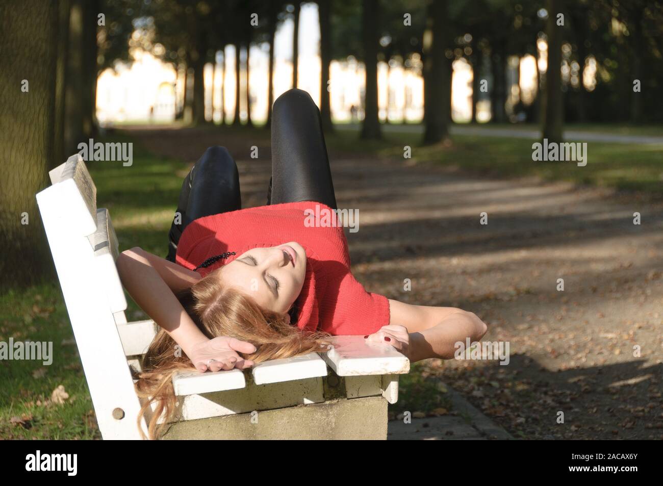 Girl on park bench in autumn Stock Photo - Alamy
