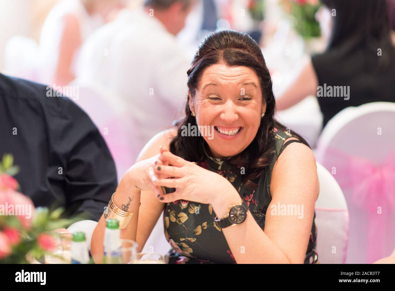 Wedding guests smiling, laughing and having fun at the wedding breakfast, letting their hair down after the ceremony and onto the reception, weddings Stock Photo