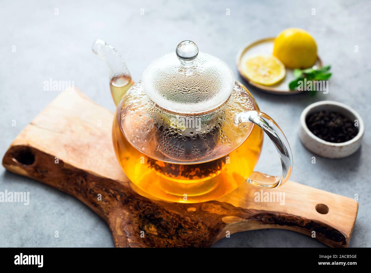 Tea in glass tea pot with lemon and mint. Fresh tea brew, herbal tea Stock Photo