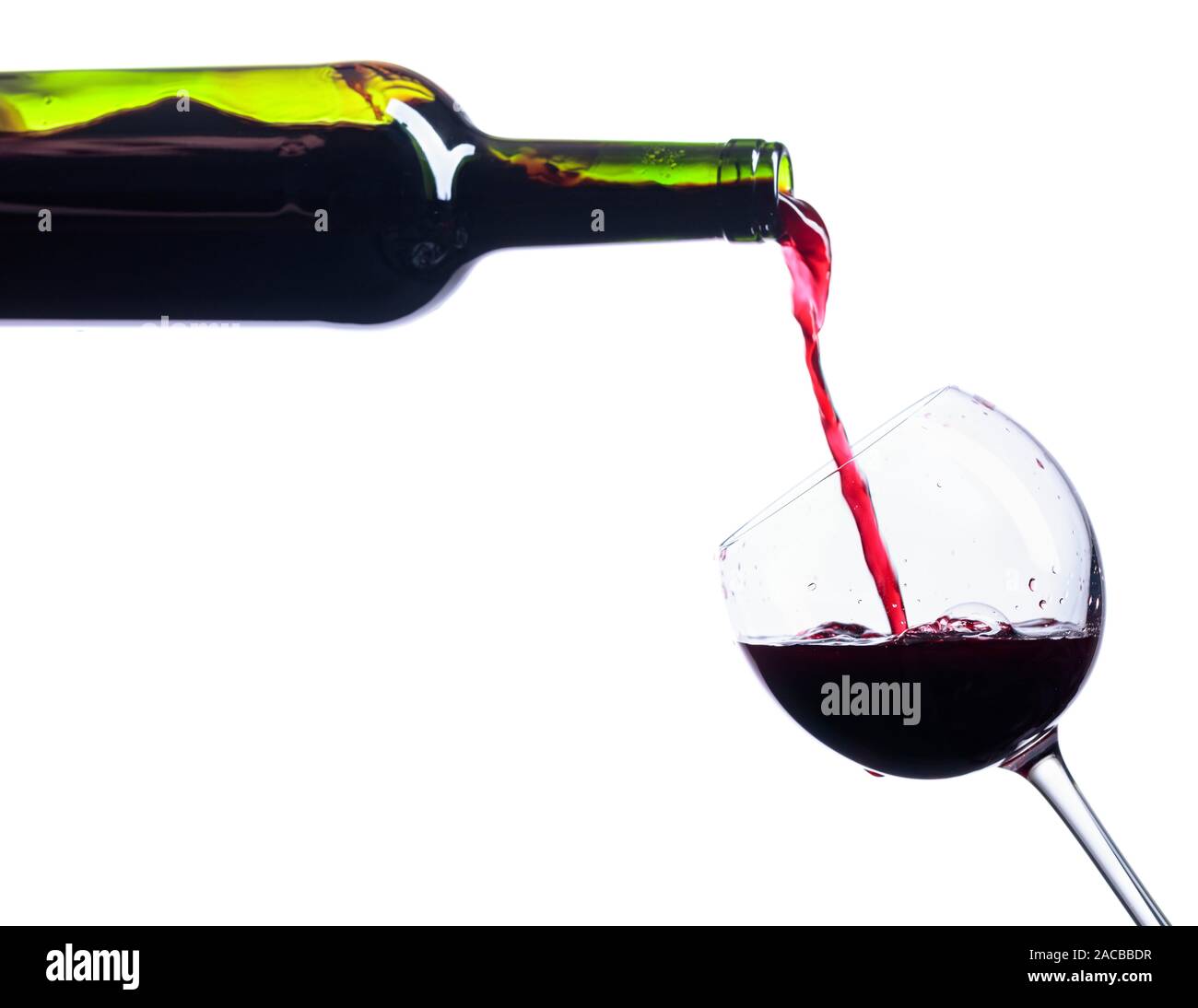 Pouring red wine from bottle to glass isolated on a white background