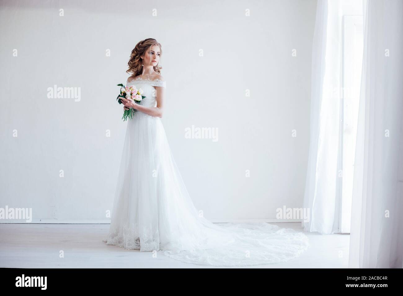 bride in wedding dress holding a bouquet of flowers Stock Photo - Alamy