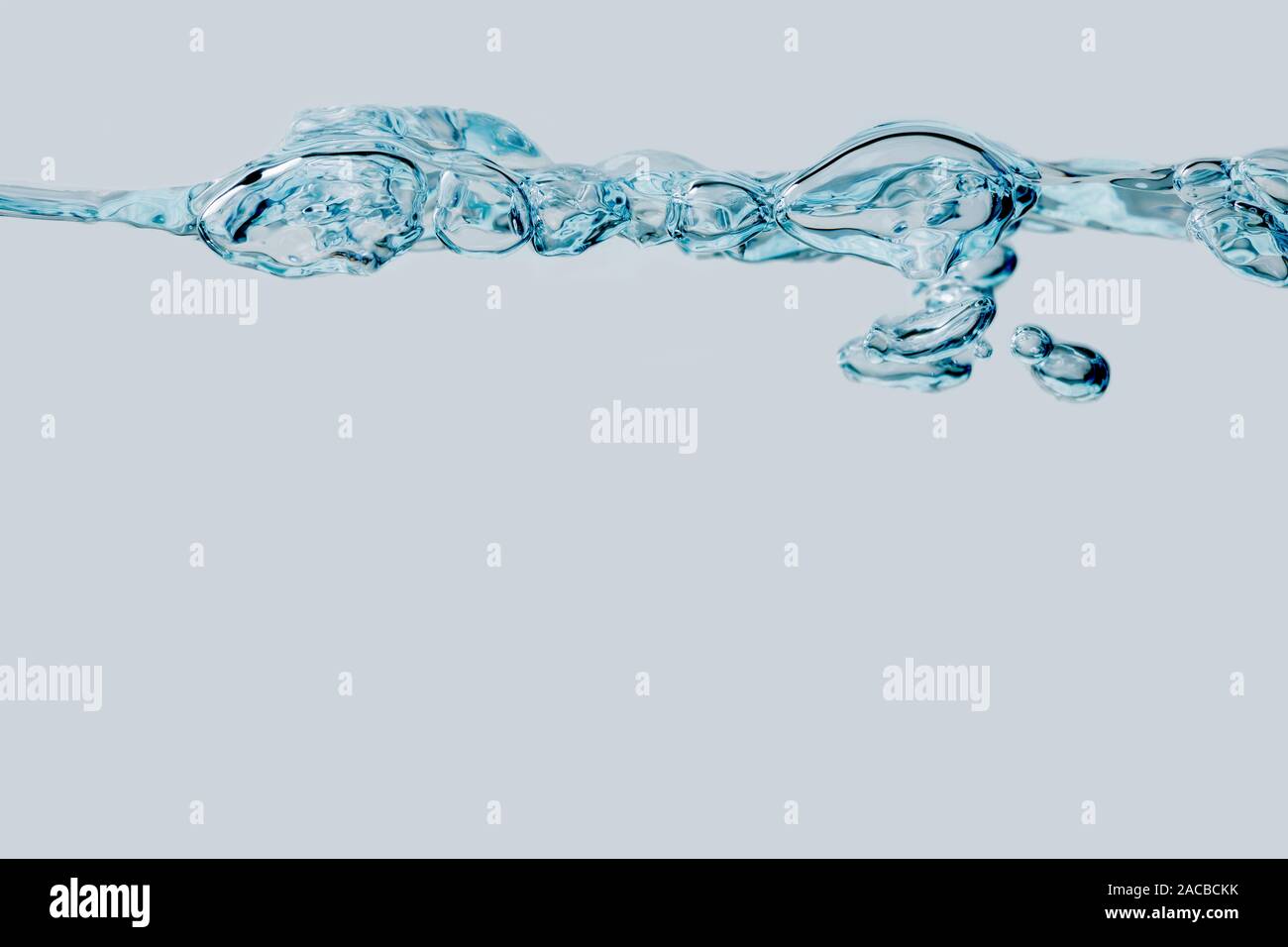 Studio shot of a series of bubbles at the water surface in side view in front of bright blue background. Stock Photo