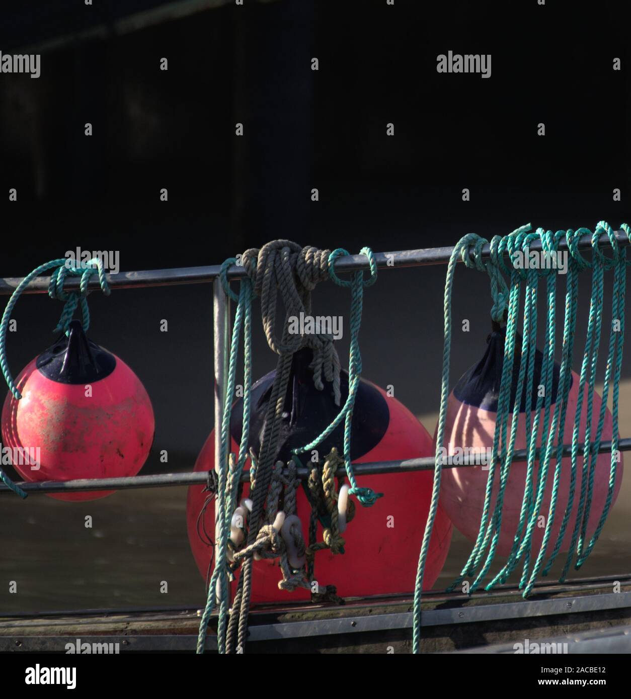 New Quay Ceredigion Wales/UK November 29 2019:  Abstract collection of red and orange boat buoys with blue/green rope. Stock Photo