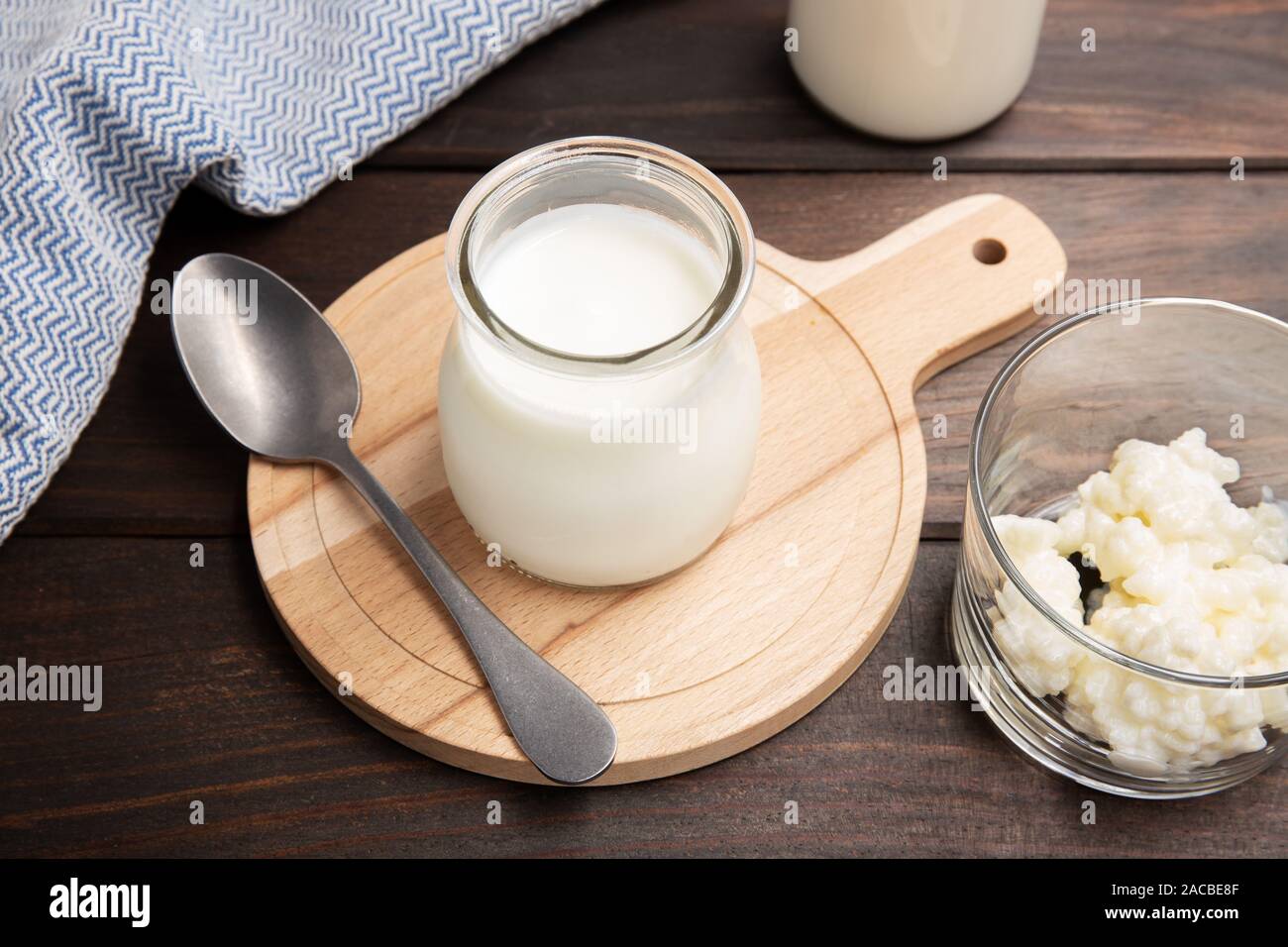 Healthy Yoghurt and kefir grains in glass on wooden table. Yeast