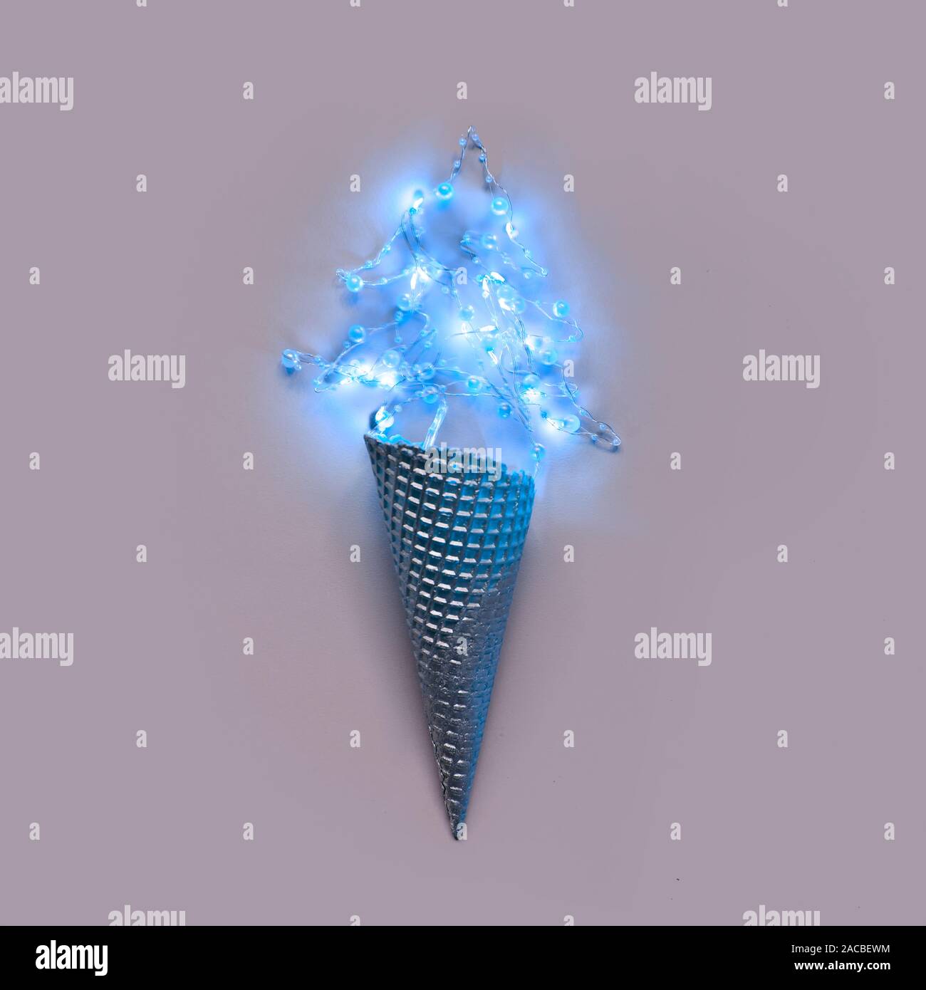 Minimum Christmas.Cream cone silver with garland on pastel grey background Stock Photo
