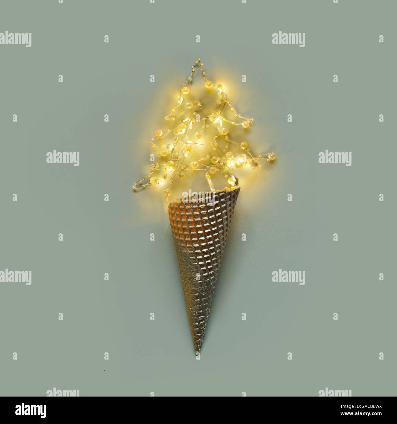 Minimum Christmas.Cream cone silver with garland on pastel grey background Stock Photo