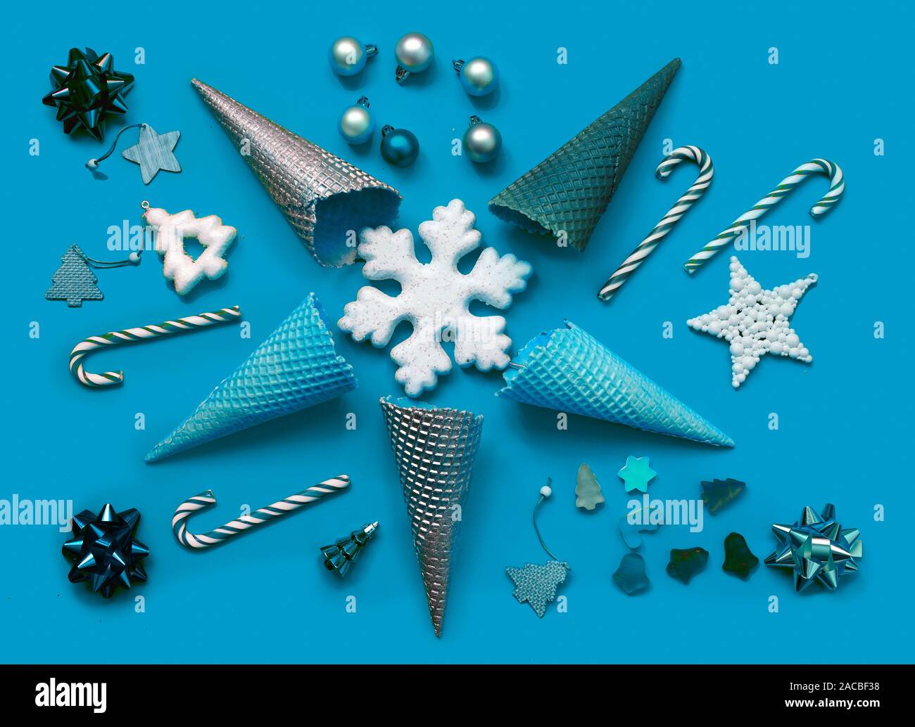 Trendy Christmas pattern made with creme cones ,candy, tree snowflake,bauble decoration on blue background. Minimal Christmas concept. Stock Photo