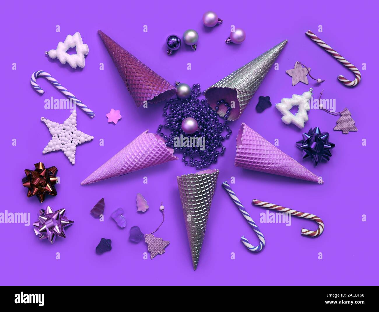Trendy Christmas pattern made with creme cones ,candy, tree snowflake,bauble decoration on proton purple background. Minimal Christmas concept. Stock Photo