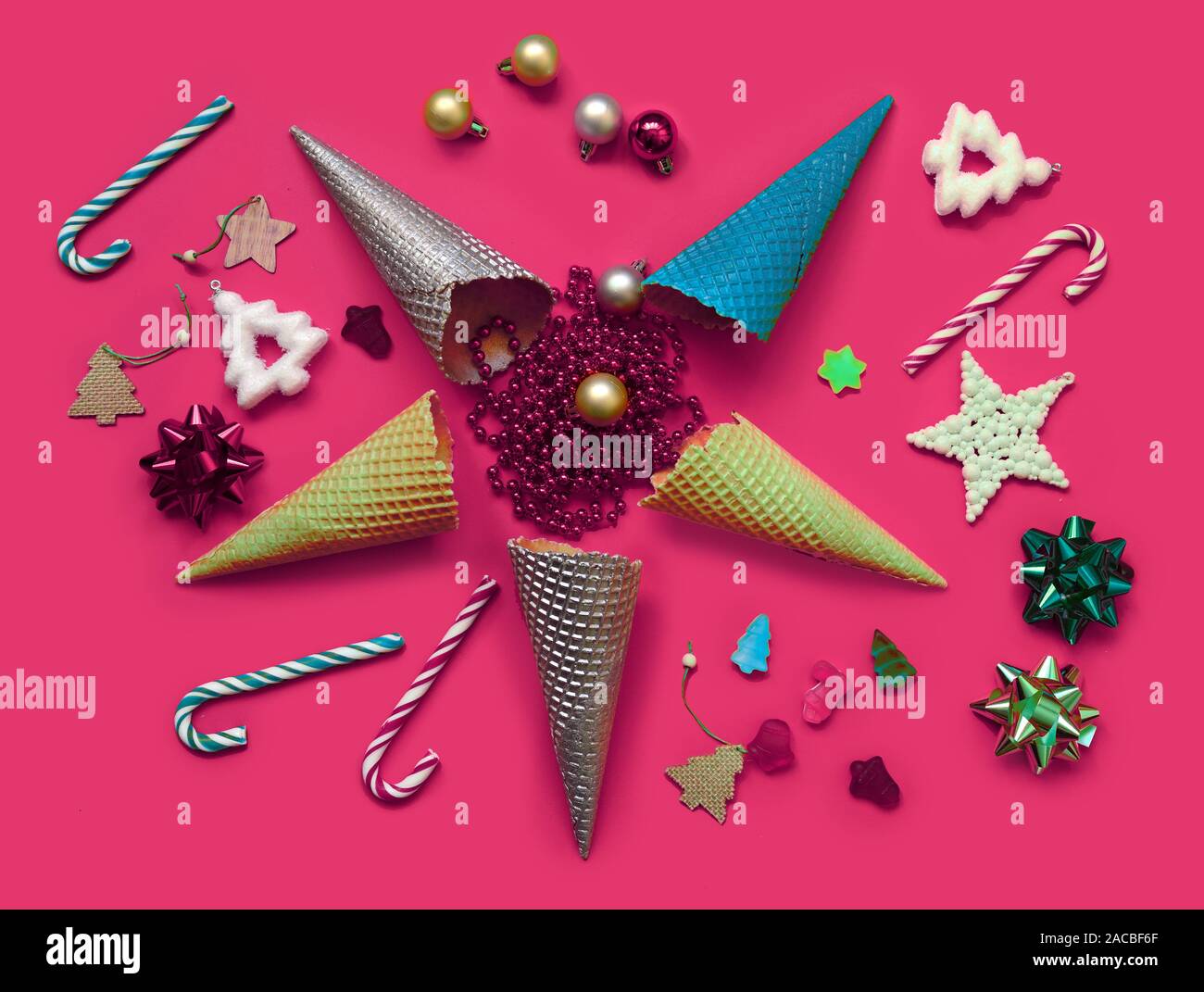Trendy Christmas pattern made with creme cones ,candy, tree snowflake,bauble decoration on bright pink background. Minimal Christmas concept. Stock Photo
