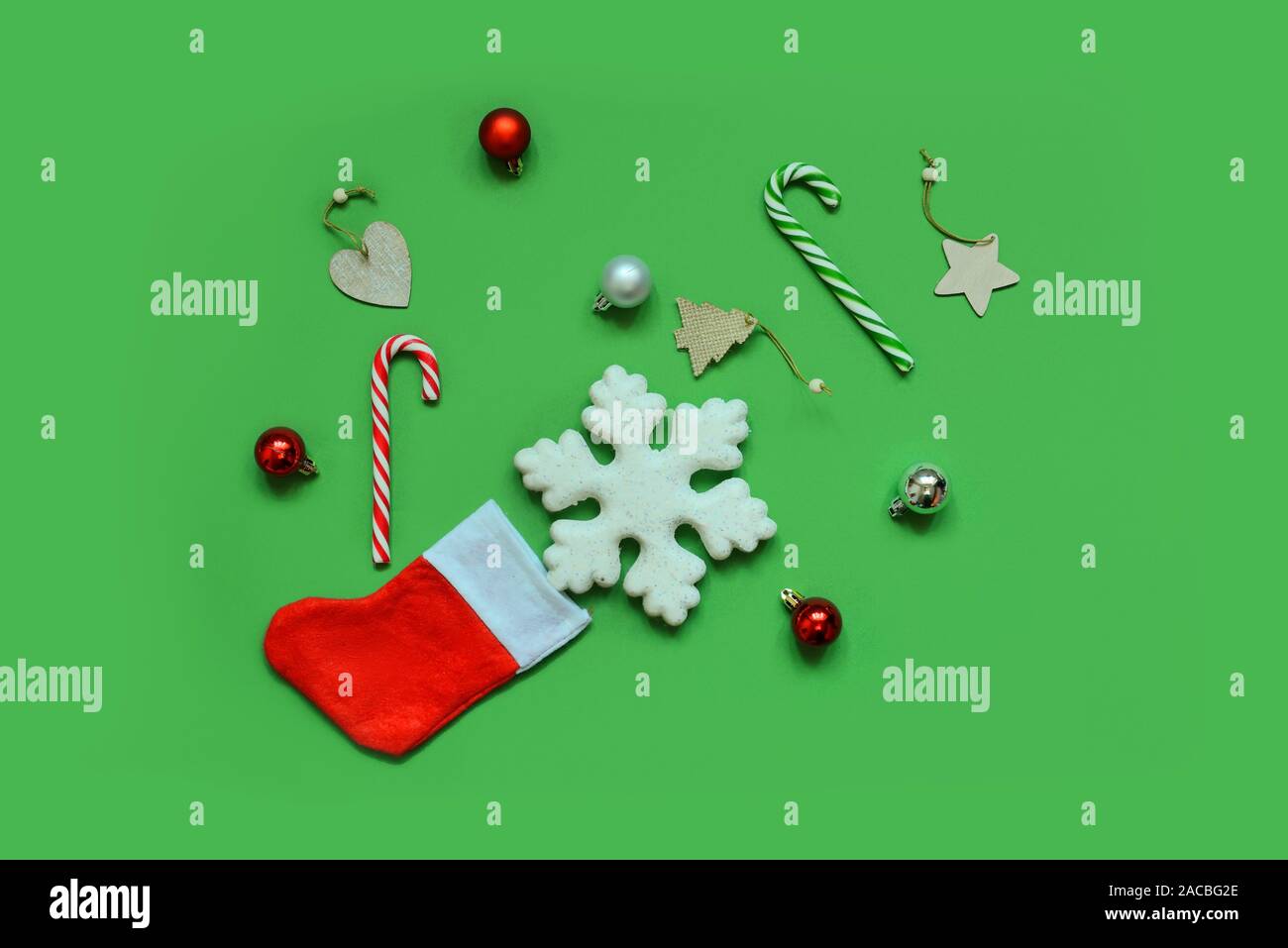 Christmas composition. Frame made of christmas gifts, pine branches, toys on green background. Flat lay, top view, copy space. Stock Photo