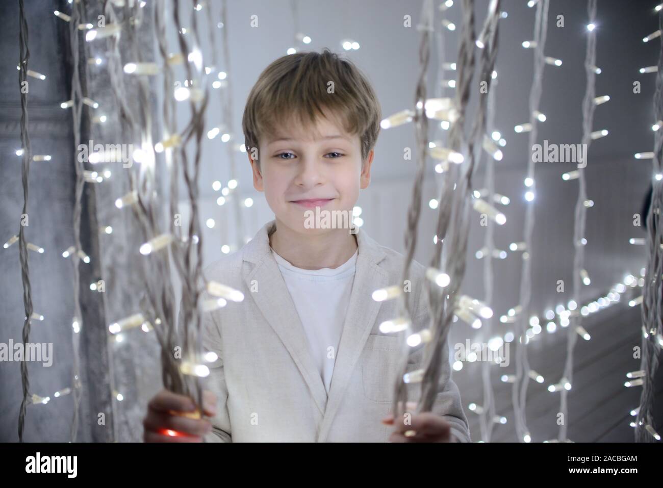 Smiling boy holding Bright Christmas garlands Stock Photo