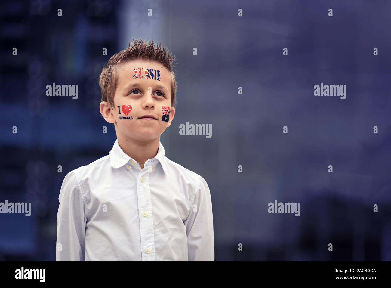 Portrait of proud Aussie boy with flag themed tattoos standing during Australian National Anthem during Australia Day celebration Stock Photo