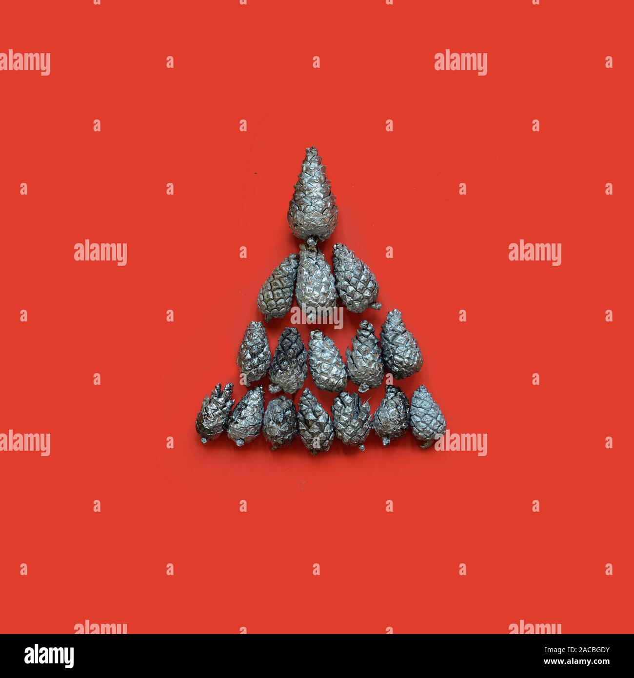 Christmas tree of silver fir cones on a red background.Minimal Christmas concept Stock Photo