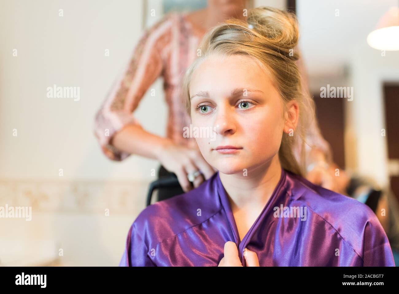 A pretty bridesmaid getting ready for the wedding day ahead, having her hair and makeup done, bridal preparation, bridal prep Stock Photo