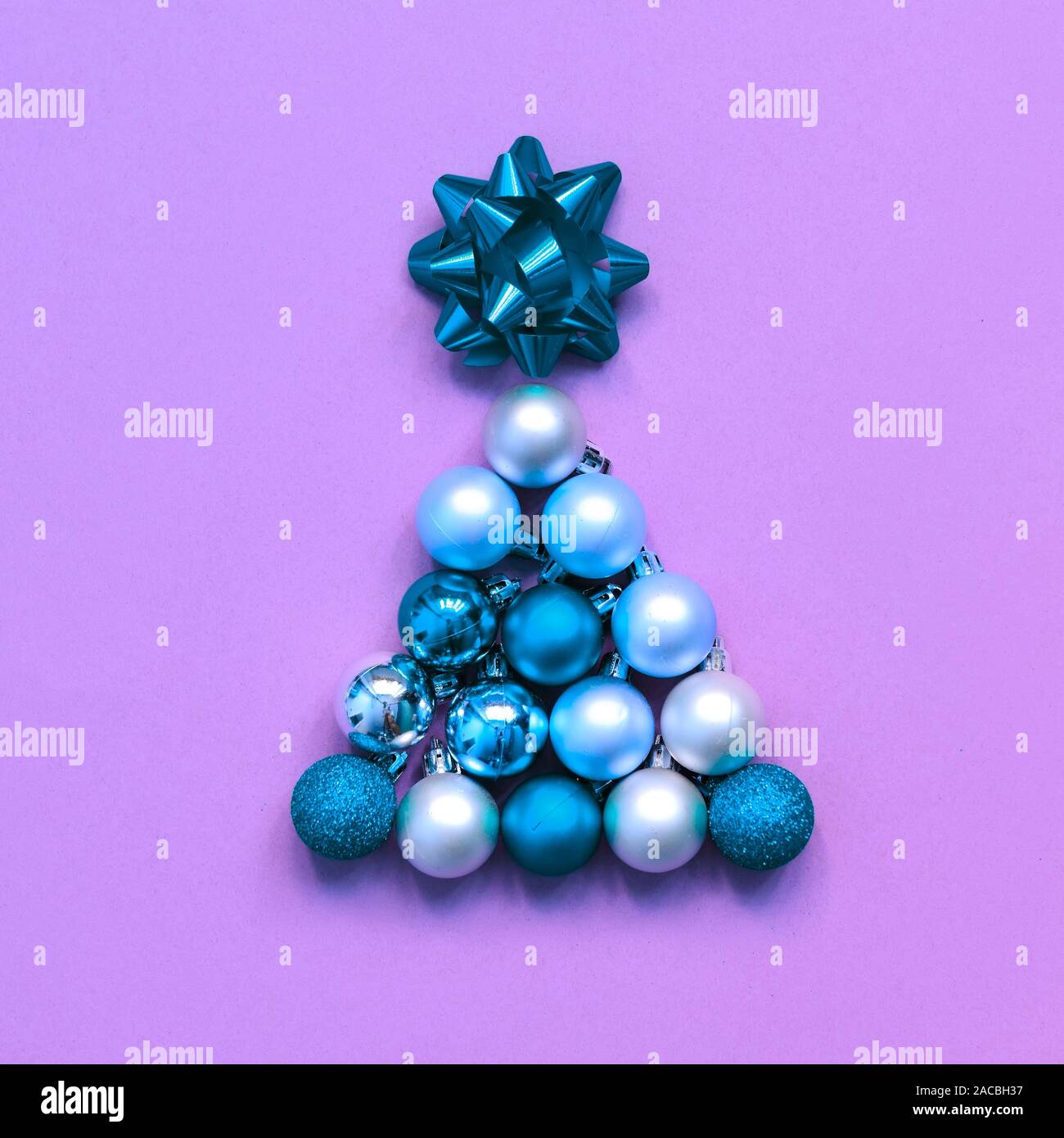 Christmas tree shape made with bauble on green background. Minimal holiday concept. Creative flat lay. Stock Photo