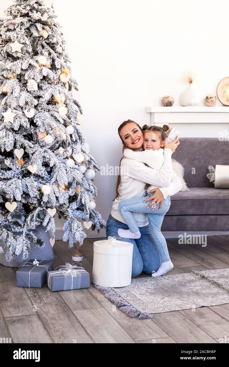Happy mother and daughter seating with gift box over living room and ...