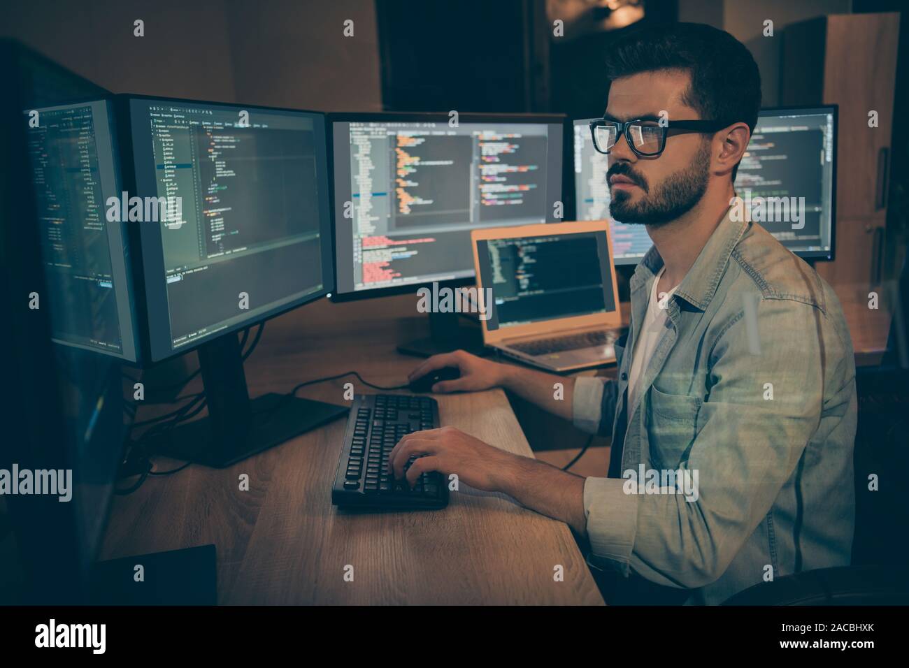 Photo of serious administrator responsible for cyber security of large corporation searching for safety gaps debugging existant operating system to Stock Photo