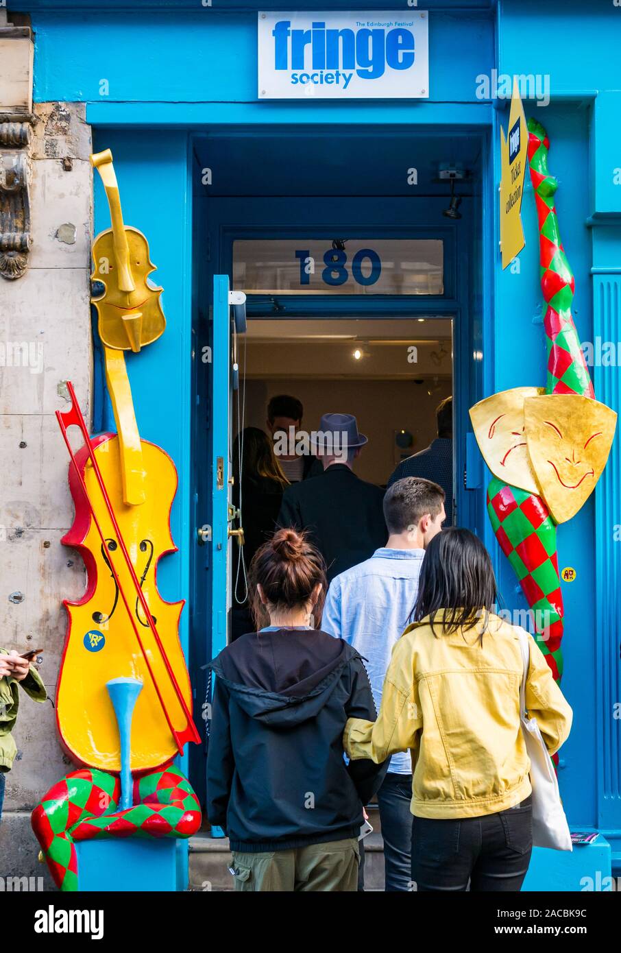 People going into colourful quirky entrance of Fringe Society Office, Royal Mile, Edinburgh, Scotland, UK Stock Photo
