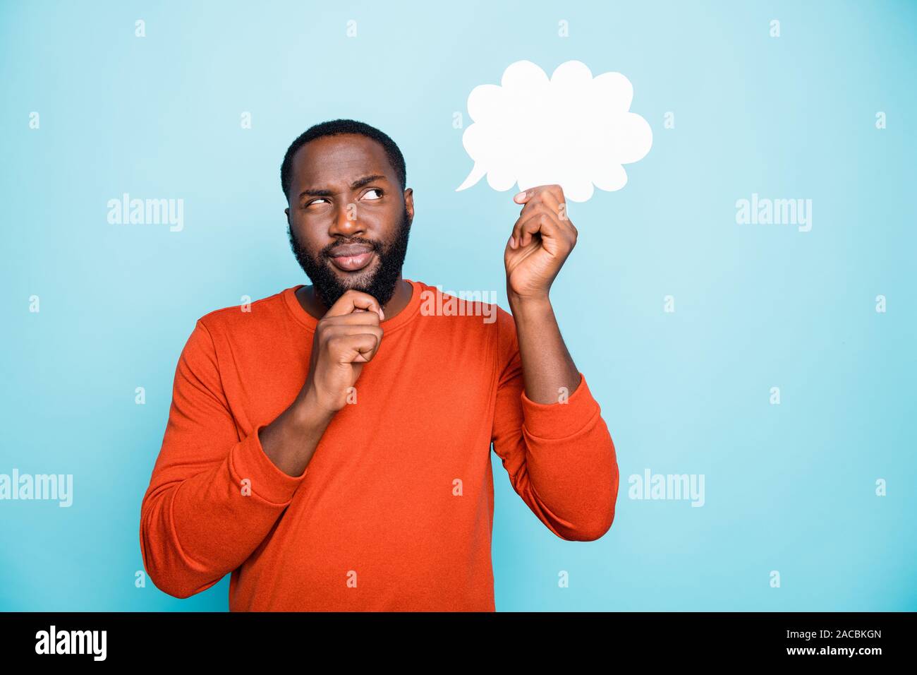 Photo of solving deciding man touching his beard in a fit of thoughts about his future concentrated on cloud he holds with hand isolated vivid color Stock Photo