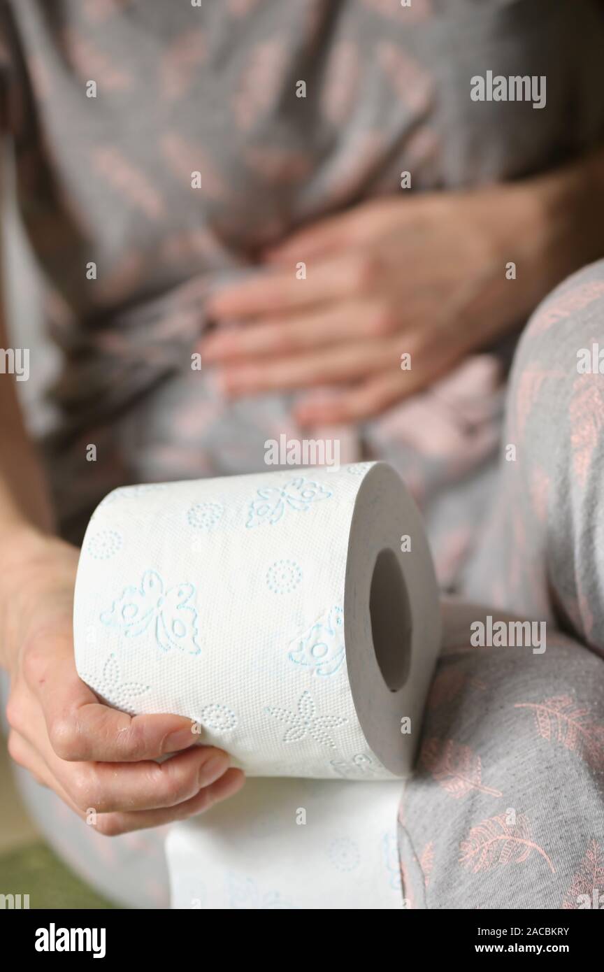 Woman Hand Holding Her Bottom And Toilet Paper Roll Stock Photo