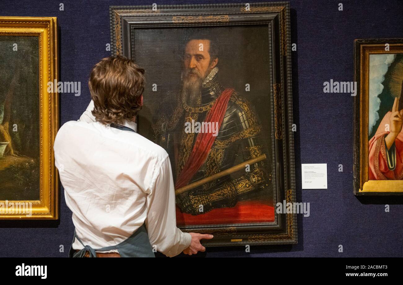 Bonhams, London, UK. 2nd December 2019. Old Masters Painting sale preview at Bonhams. Image: Painting being hung by Bonhams art handler, Studio of Antonis Mor (Utrecht 1517-1575 Antwerp?). Portrait of Fernando Álvarez de Toledo y Pimentel, 3rd Duke of Alba, half-length, wearing armour, a red sash, a white ruff and Order of the Golden Fleece, holding a baton. Credit: Malcolm Park/Alamy Live News. Stock Photo