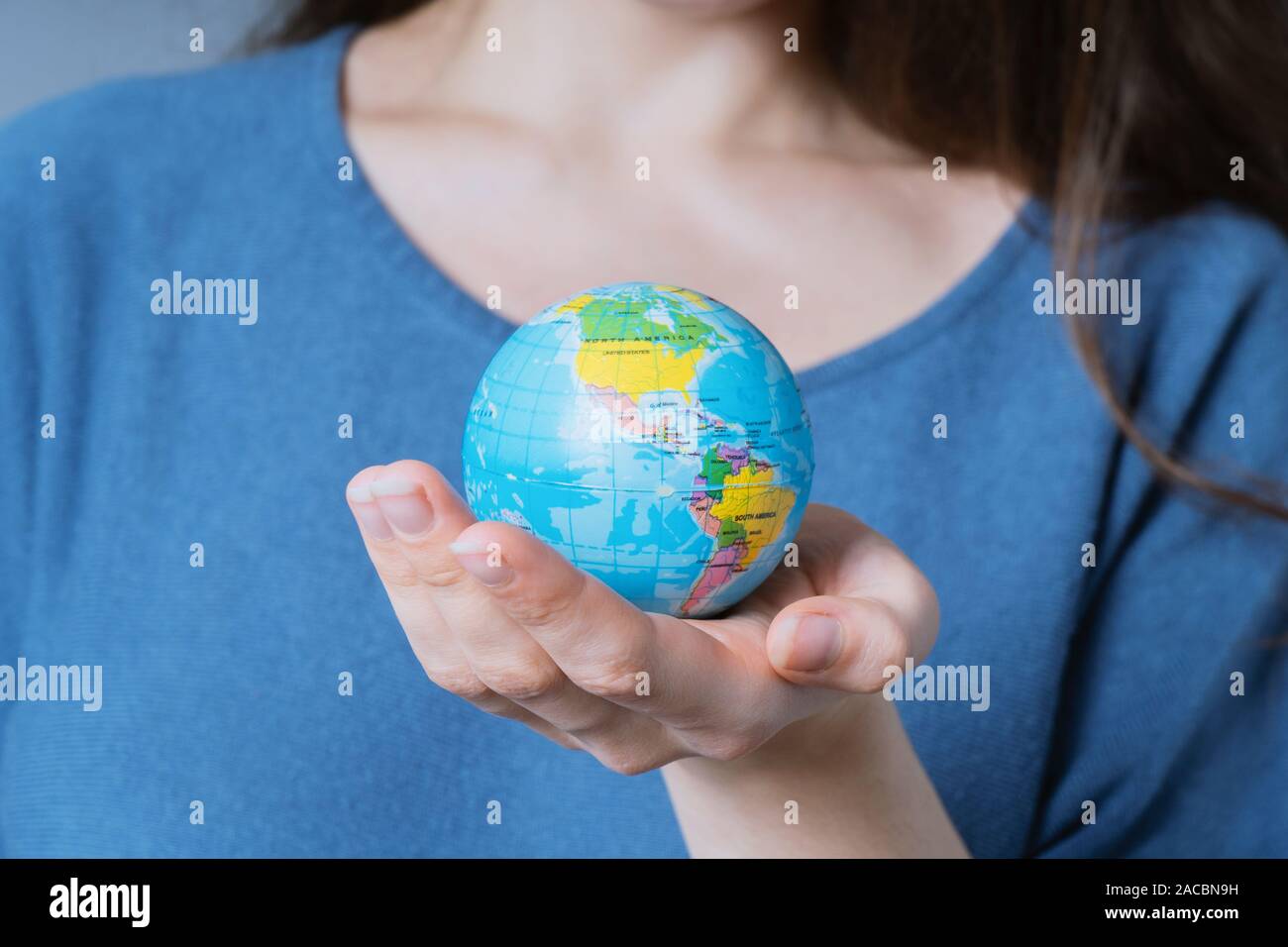 young unrecognizable woman holding world globe in her hands - travel or environmnetal protection concept Stock Photo