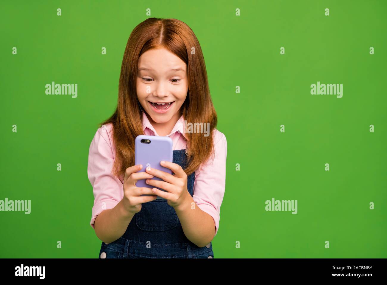 Photo of cheerful little schoolchild holding telephone hands texting with classmates friends reading funny jokes wear denim overall pink shirt Stock Photo - Alamy Photo of cheerful little schoolchild holding telephone hands texting with classmates friends reading funny jokes wear denim overall pink shirt Stock Photo - Alamy