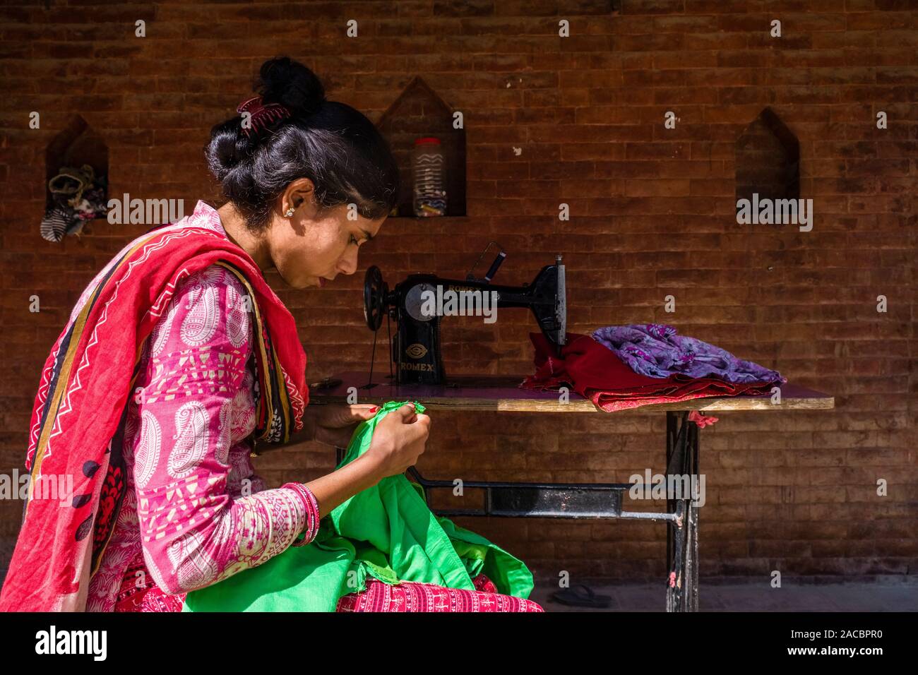 Tailor woman is working with green fabric Stock Photo